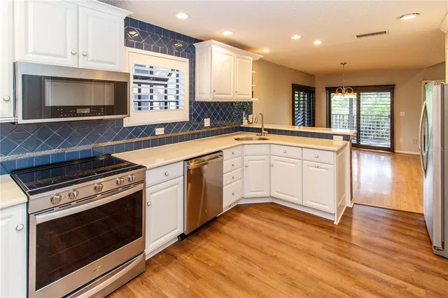 a kitchen with granite countertop a stove a sink and a microwave