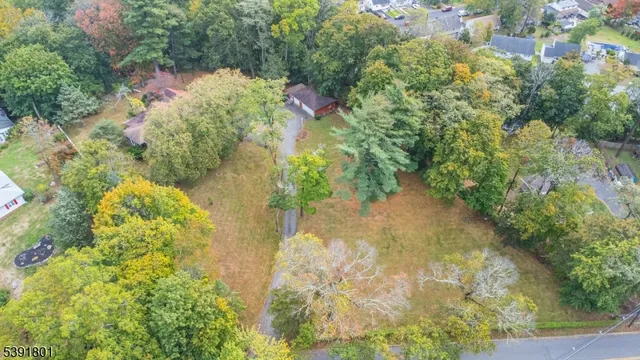 an aerial view of residential house with outdoor space and trees all around
