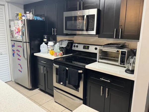 a kitchen with stainless steel appliances granite countertop a stove and a microwave