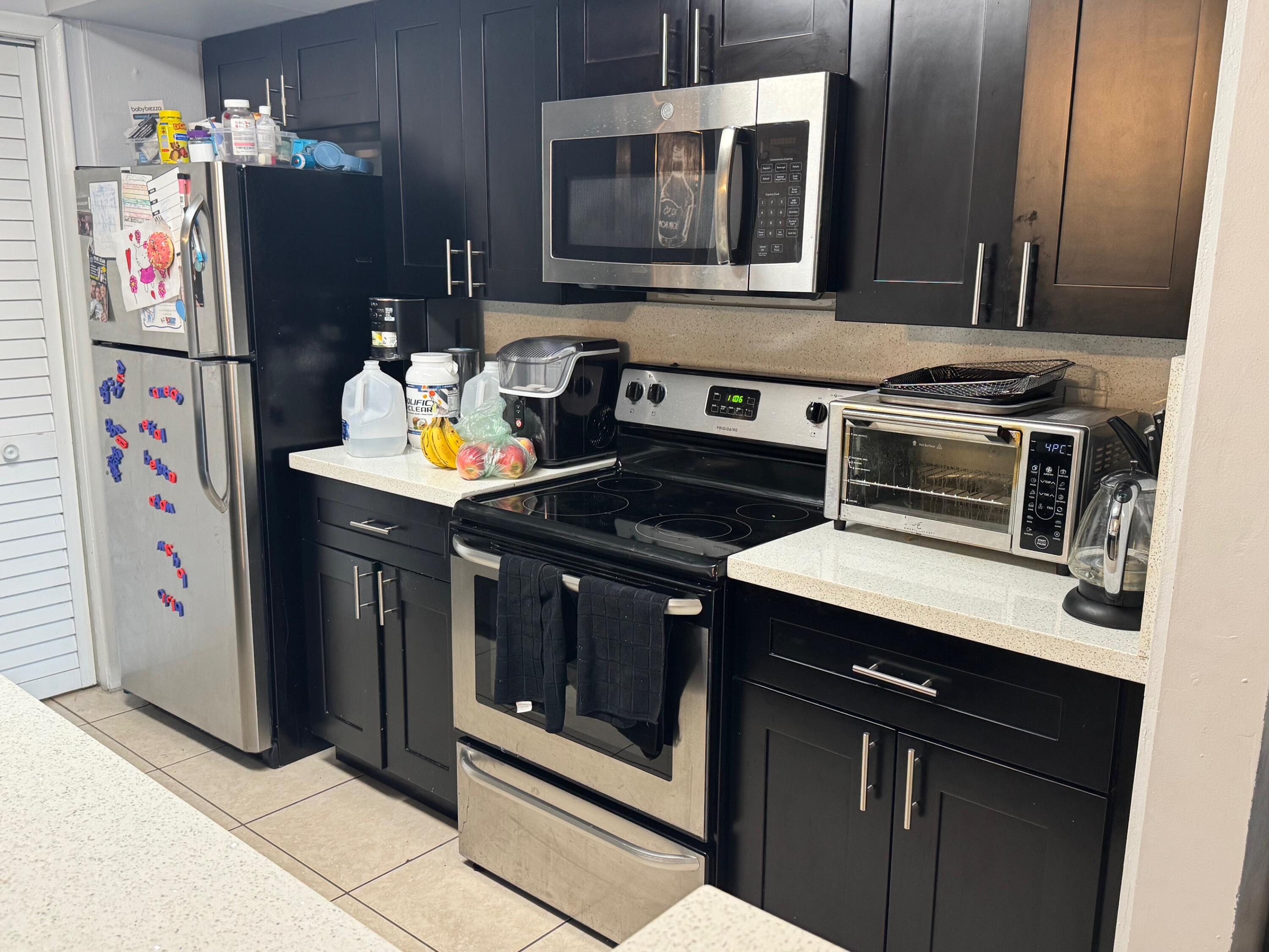4952 Sheridan Street, Unit 2 Hollywood, FL 33021 - Photo 2 of 8 a kitchen with stainless steel appliances granite countertop a stove and a microwave