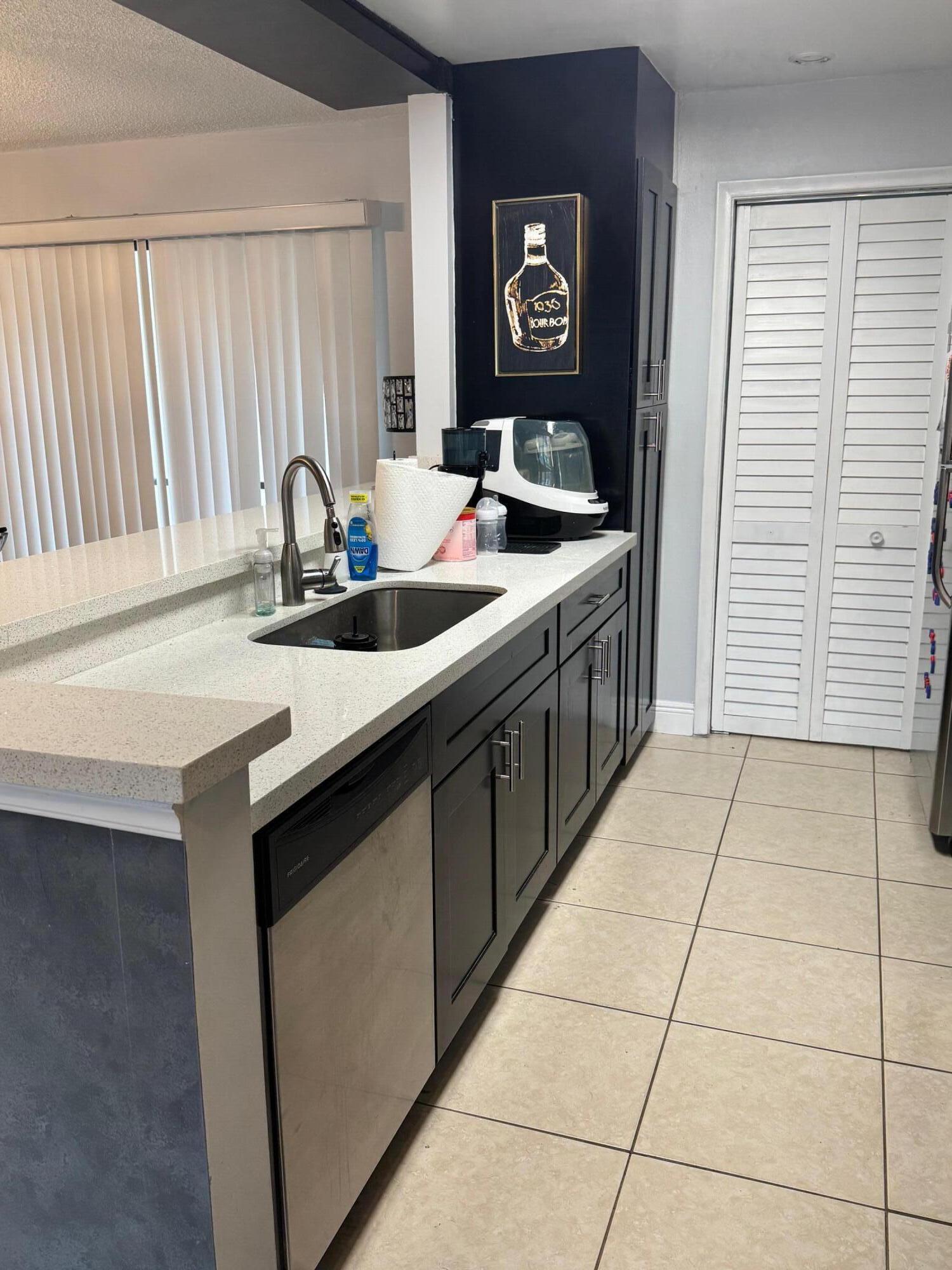 4952 Sheridan Street, Unit 2 Hollywood, FL 33021 - Photo 3 of 8 a kitchen with a sink and a refrigerator