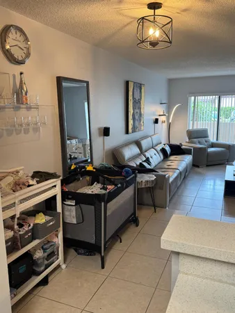 a living room with furniture a flat screen tv and a window