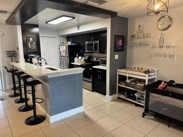 a kitchen with stainless steel appliances kitchen island granite countertop a stove a sink and a refrigerator