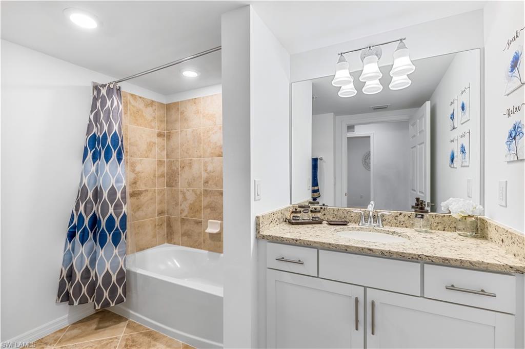 15943 Grassland Lane, Unit 3912 Babcock Ranch, FL 33982 - Photo 15 of 20 a bathroom with a granite countertop sink a mirror a vanity and a shower