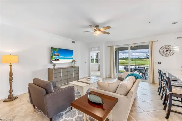 a living room with furniture a flat screen tv and a large window