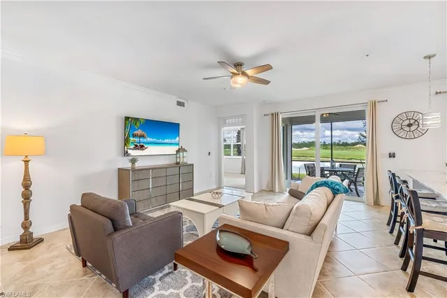 a living room with furniture a flat screen tv and a large window