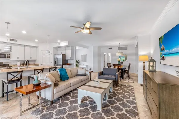 a living room with lots of furniture and kitchen view