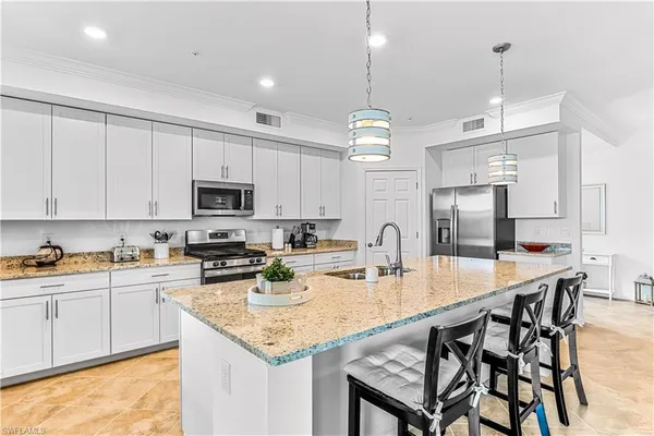 a kitchen with sink a center island and appliances