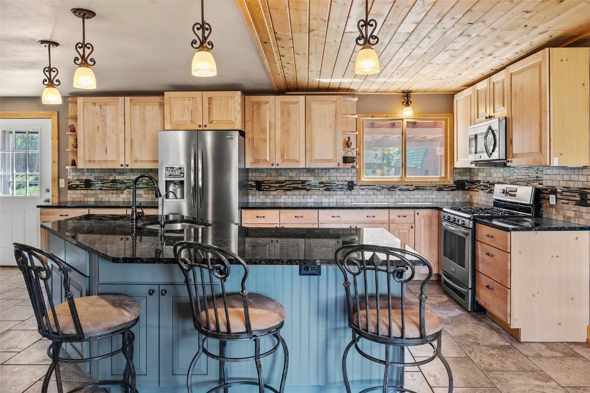 367 G Road Silverthorne, CO 80498 - Photo 5 of 50 a kitchen with stainless steel appliances granite countertop a stove a sink dishwasher a dining table and chairs with wooden floor