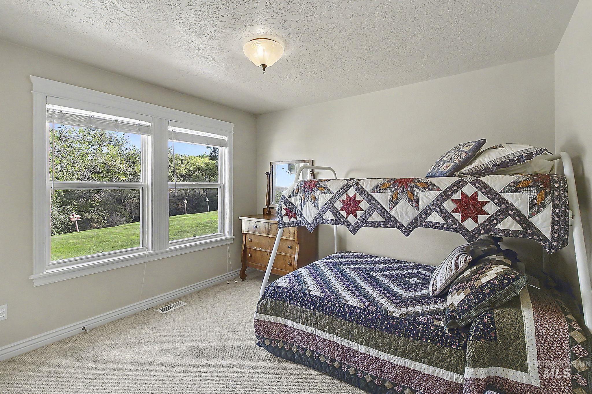 6900 West Charters Lane Melba, ID 83641 - Photo 26 of 49 Carpeted room featuring a vaulted ceiling, dual windows with blinds, and a flush mount ceiling light