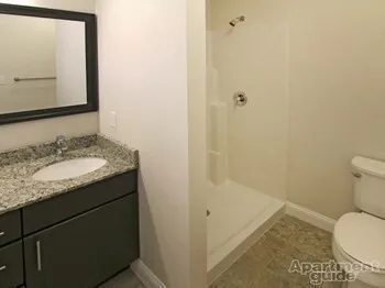 a bathroom with a granite countertop sink toilet and shower