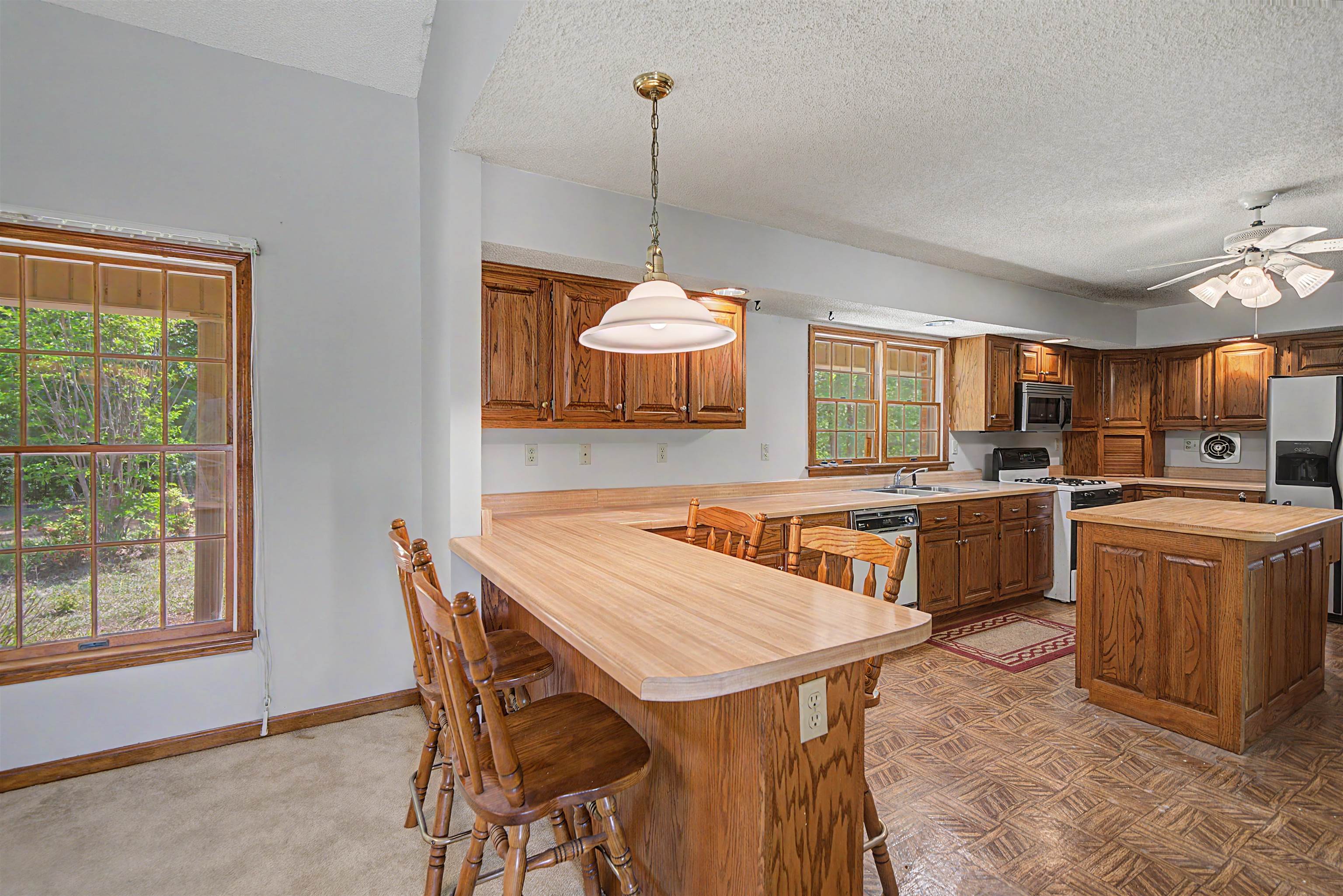 162 Lawton Road Selmer, TN 38375 - Photo 14 of 36 Kitchen featuring wood cabinetry, wood-finish countertops, and a central island with a matching wood-finish top