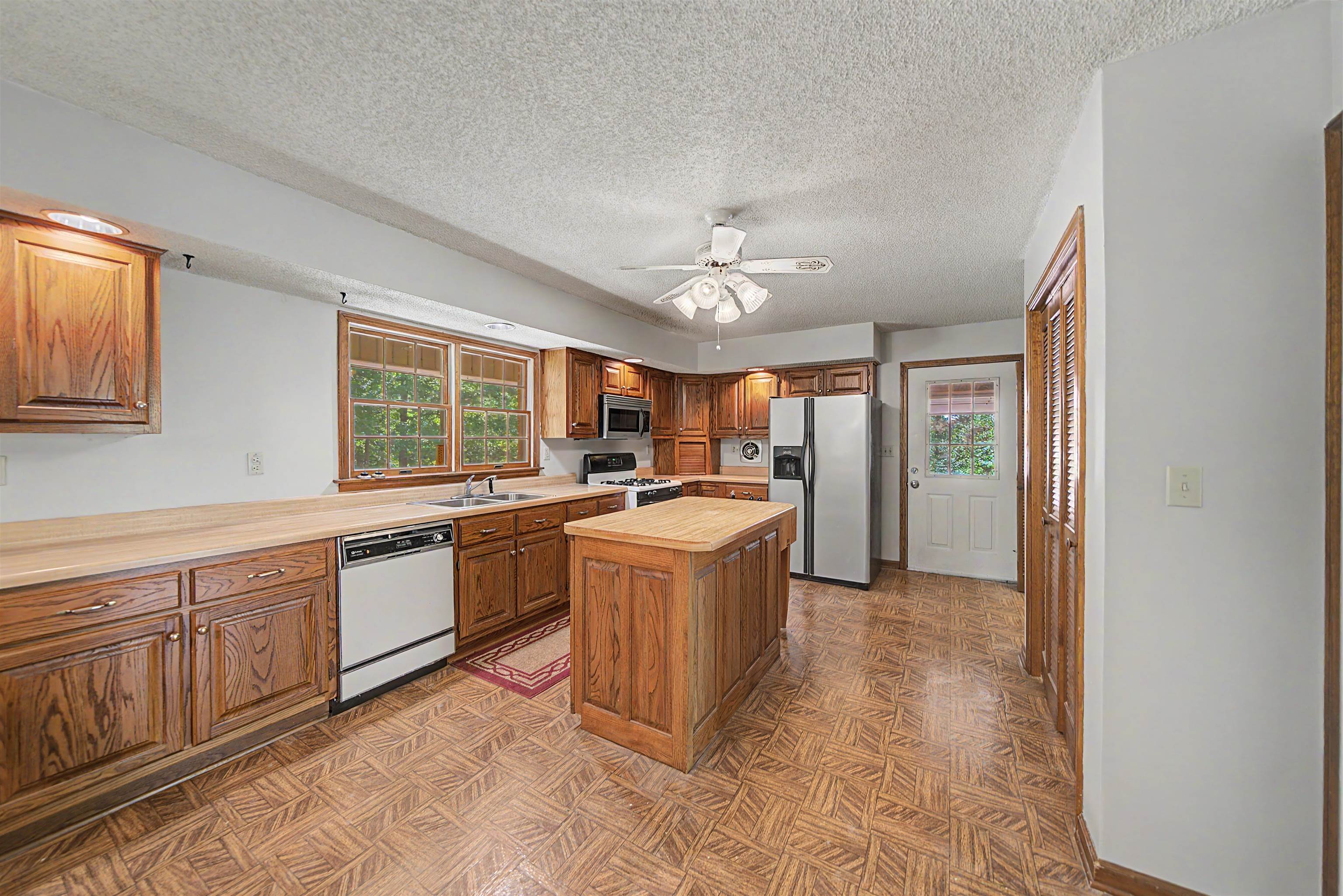 162 Lawton Road Selmer, TN 38375 - Photo 15 of 36 Kitchen featuring wood-finish cabinetry, a central island with countertop, and wood-finish flooring