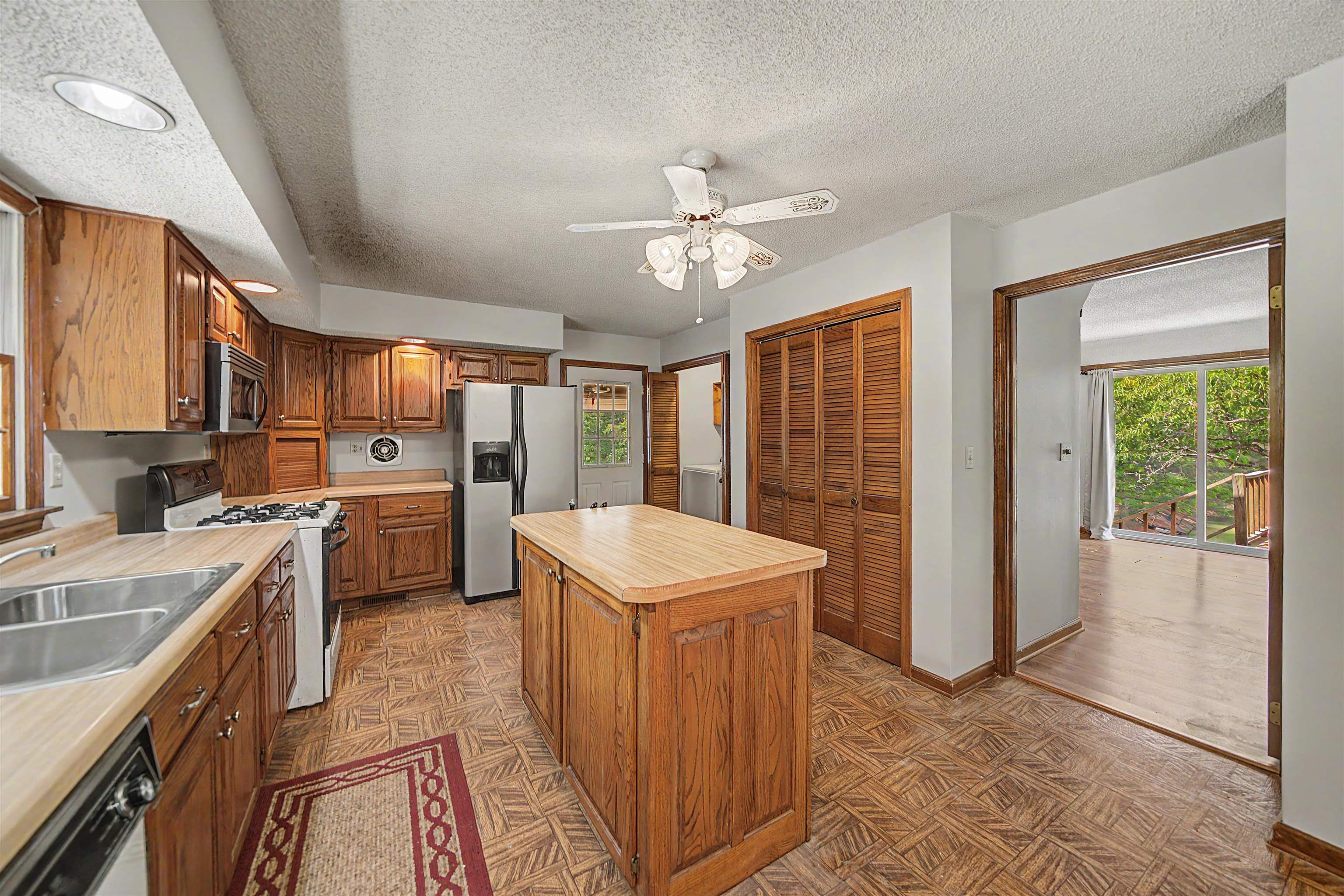 162 Lawton Road Selmer, TN 38375 - Photo 16 of 36 Kitchen featuring wood cabinetry, a center island with a wood-finish countertop, stainless steel appliances, and a gas range