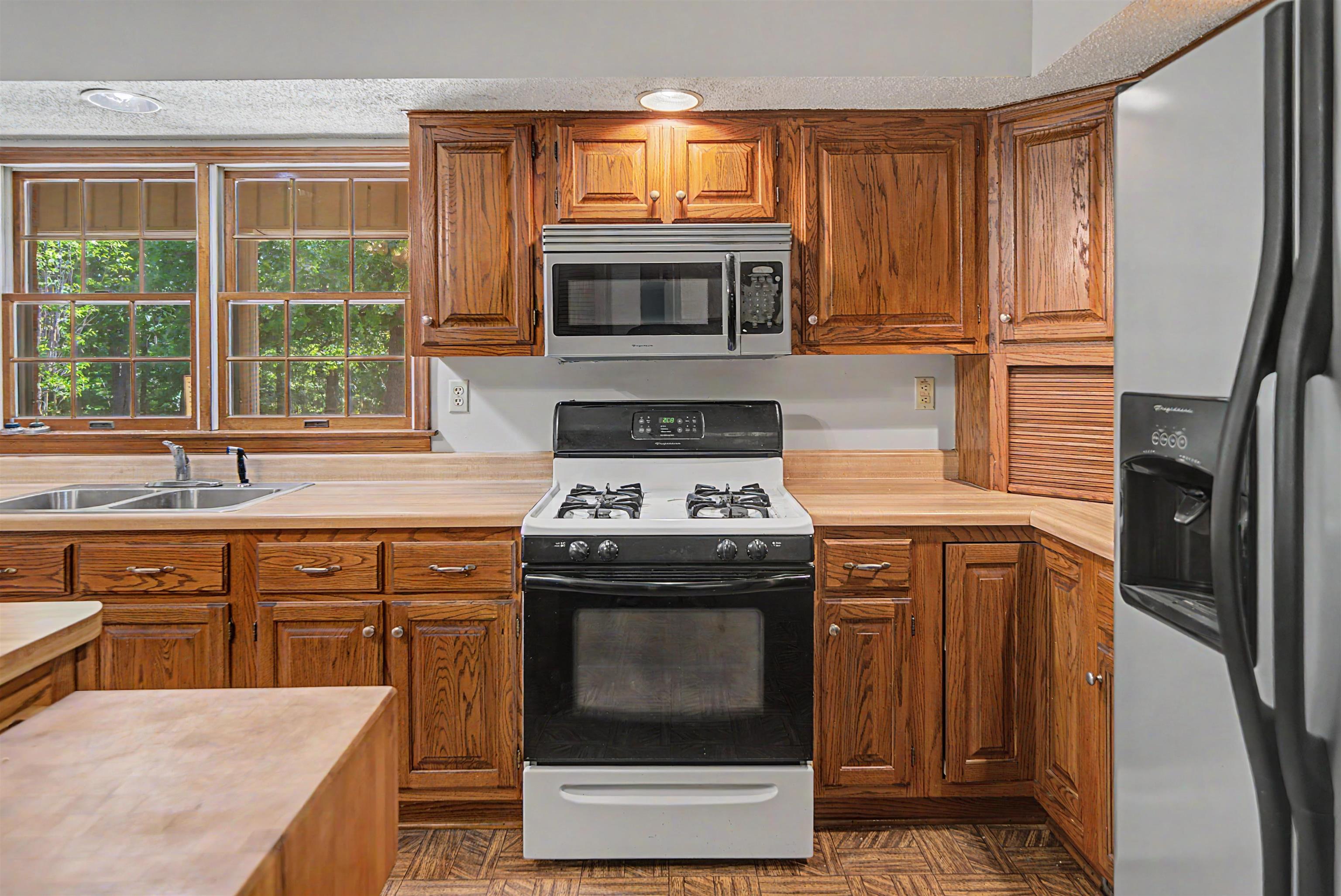 162 Lawton Road Selmer, TN 38375 - Photo 17 of 36 Kitchen with wood cabinetry, light countertops, and a stainless steel over-the-range microwave