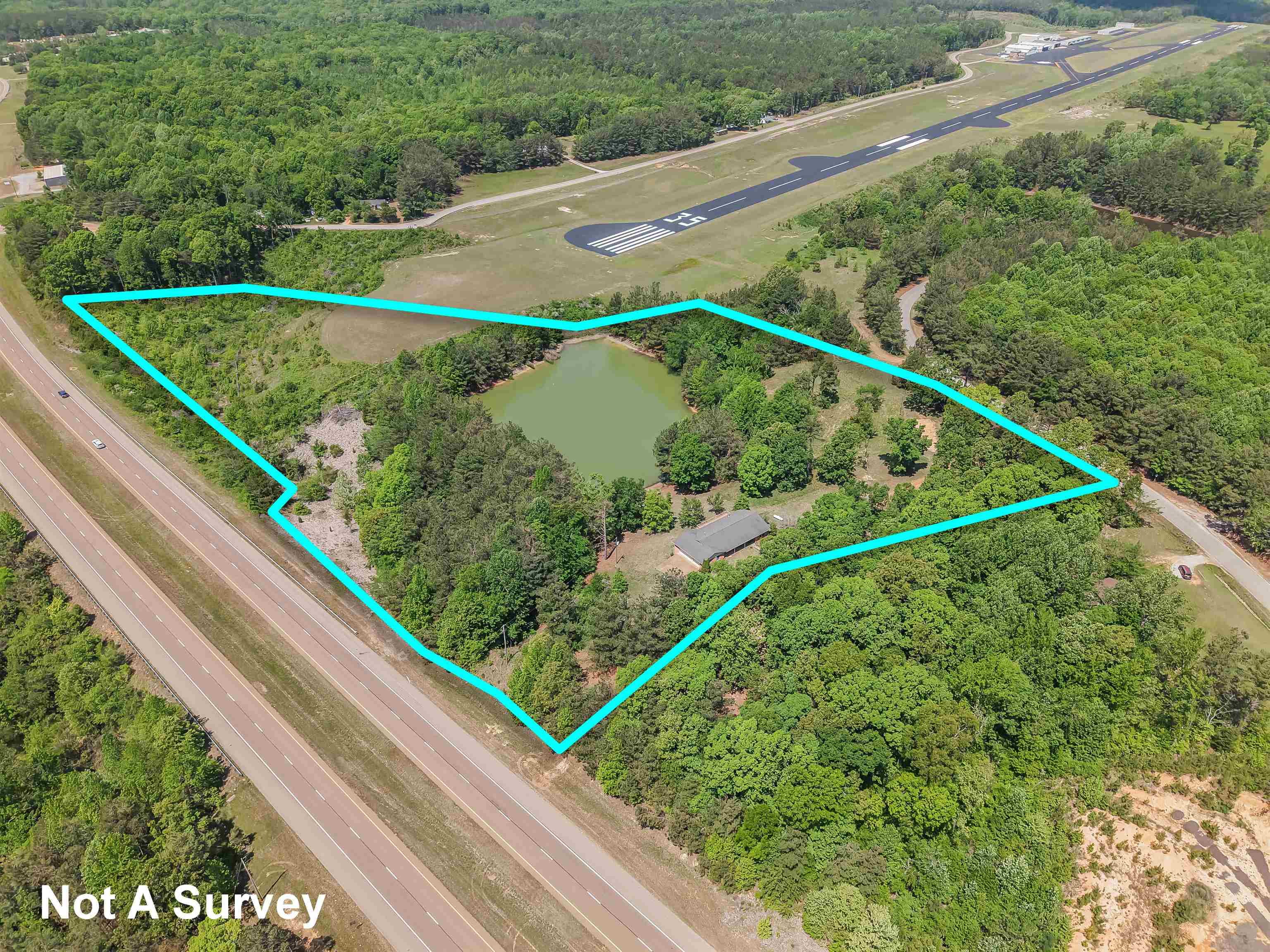 162 Lawton Road Selmer, TN 38375 - Photo 2 of 36 Expansive land parcel featuring a private pond and a single-story structure with a dark roof