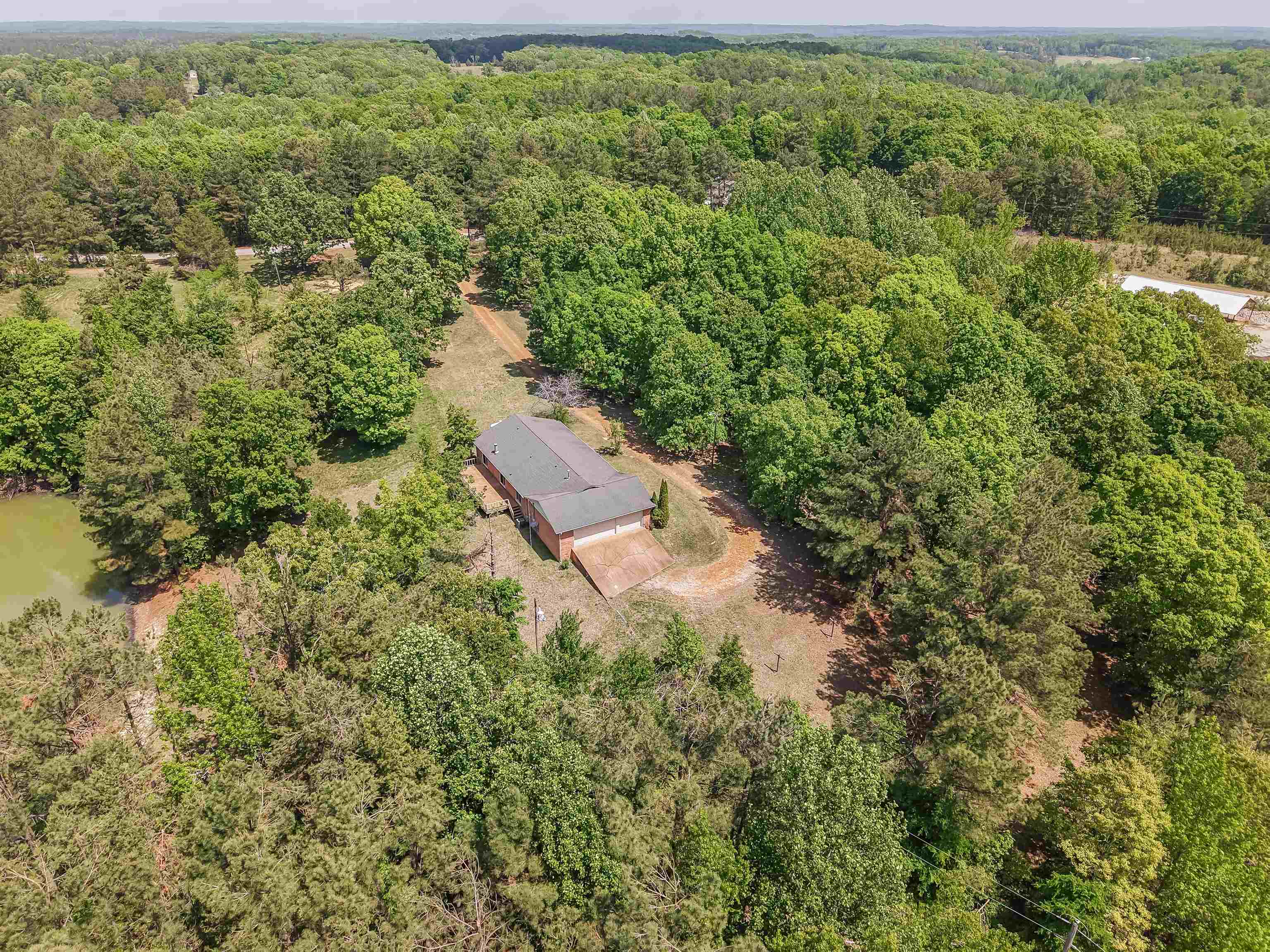 162 Lawton Road Selmer, TN 38375 - Photo 28 of 36 Expansive wooded acreage featuring a brick-sided residence with an attached garage and a private pond