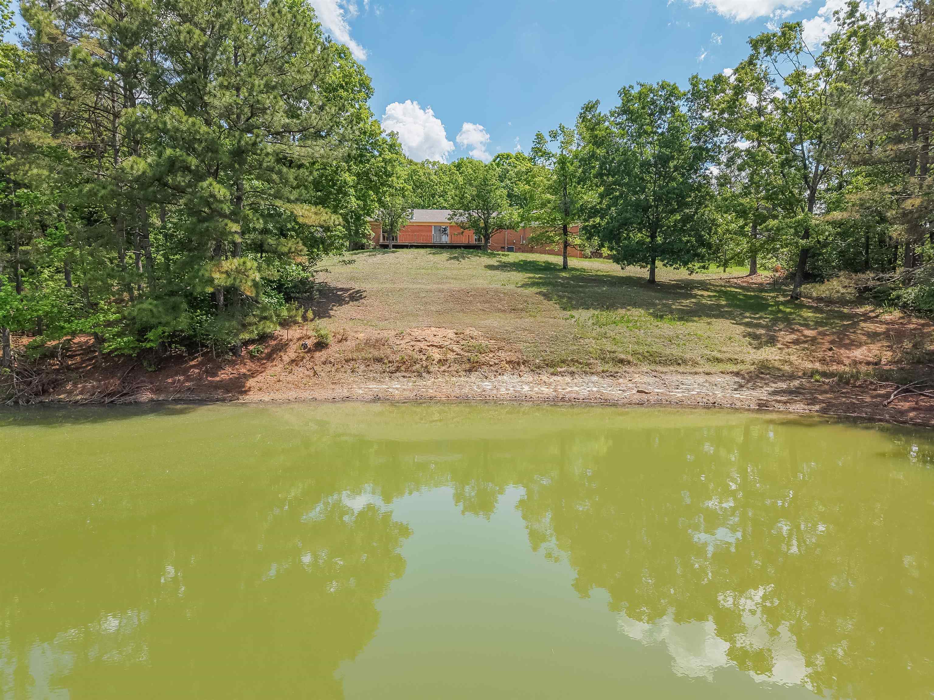 162 Lawton Road Selmer, TN 38375 - Photo 31 of 36 Waterfront property featuring a wooded perimeter and a cabin-style residence on a graded lot