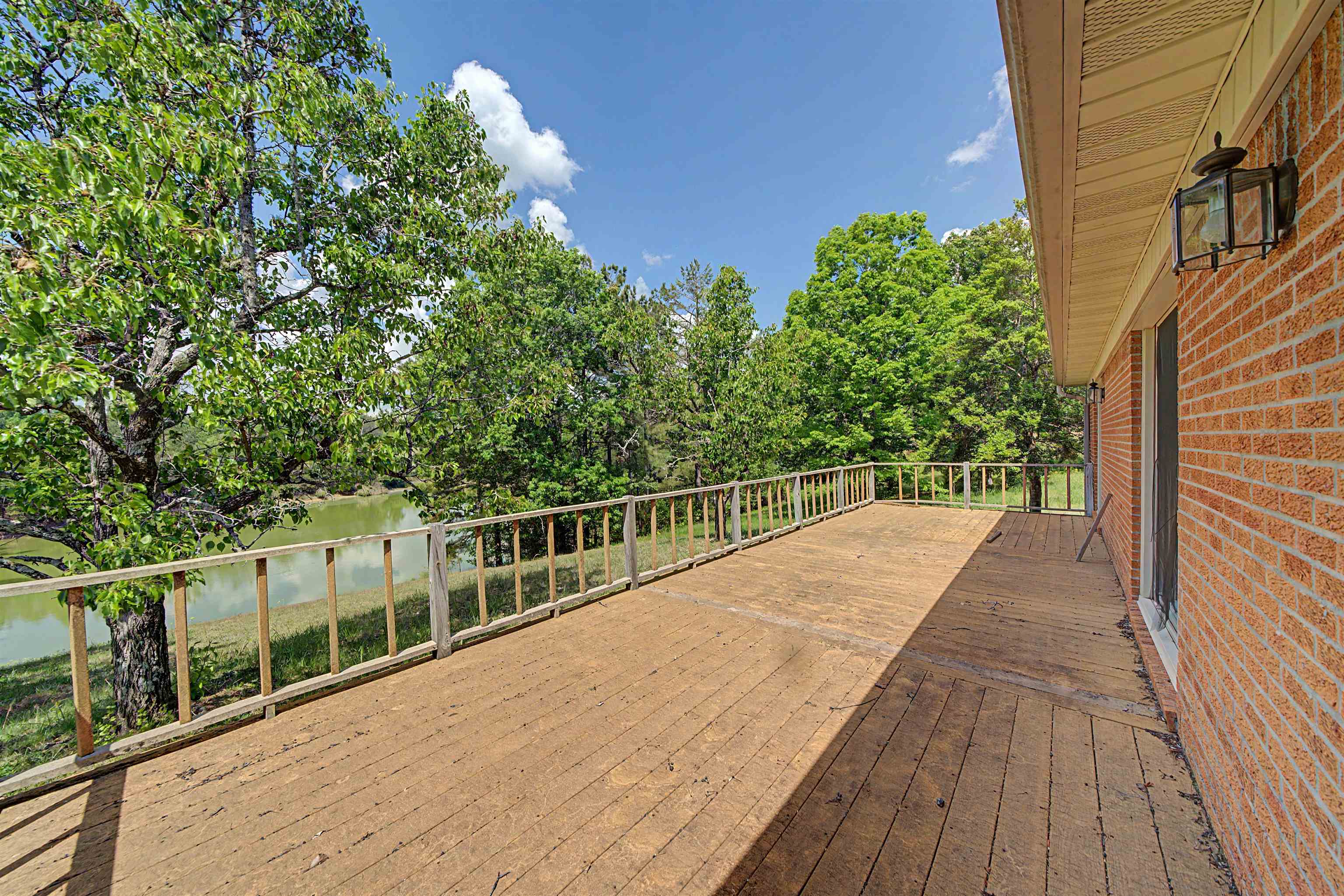 162 Lawton Road Selmer, TN 38375 - Photo 34 of 36 Expansive wood-finish deck with a wooden railing system, offering exterior access and overlooking a body of water