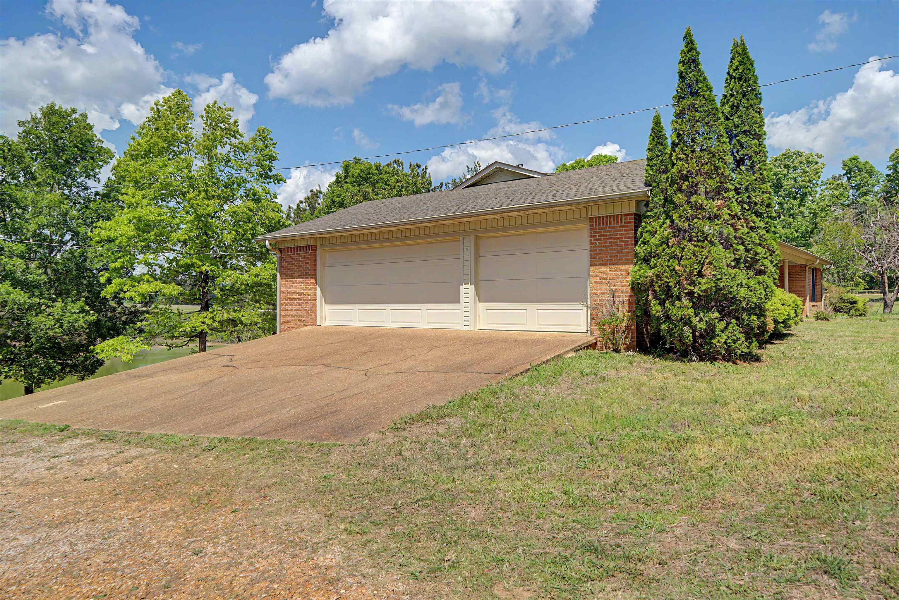 162 Lawton Road Selmer, TN 38375 - Photo 5 of 36 Brick exterior with a dual garage featuring two overhead doors