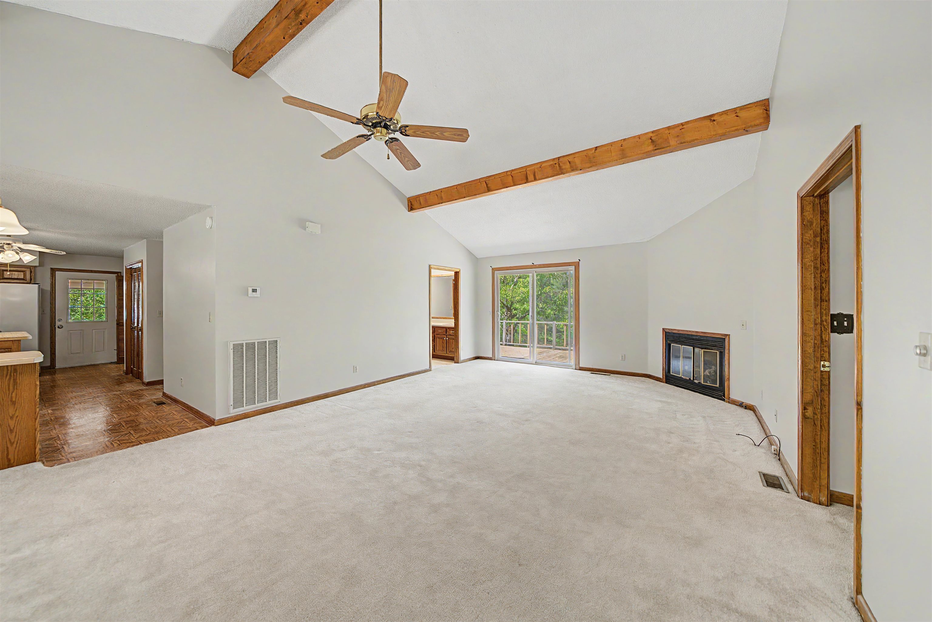 162 Lawton Road Selmer, TN 38375 - Photo 10 of 36 Spacious living area featuring a vaulted ceiling with exposed wood beams, a ceiling fan, and light-toned carpet flooring