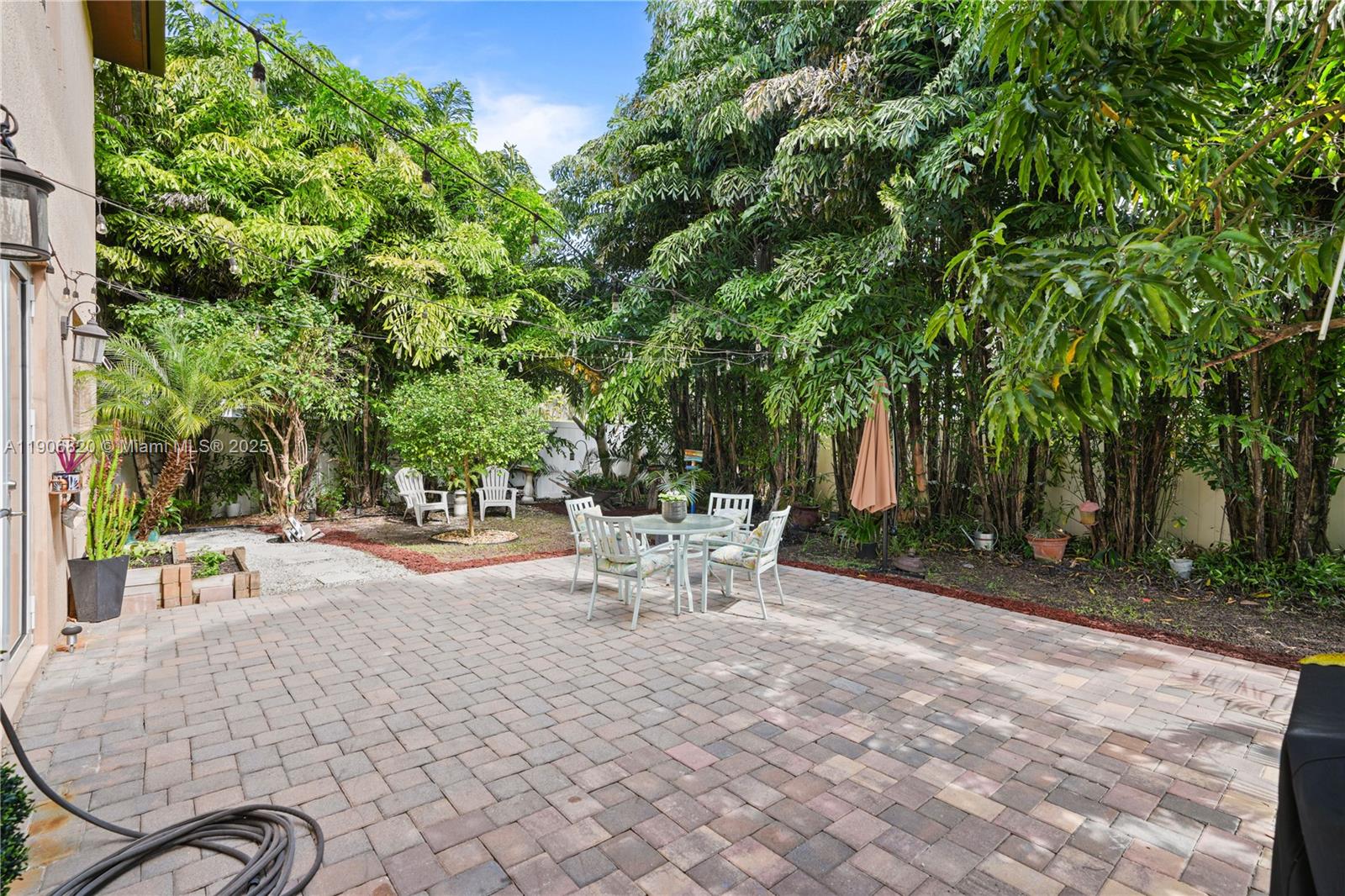 9127 Southwest 171st Court Miami, FL 33196 - Photo 46 of 54 a view of a backyard with table and chairs potted plants and tree