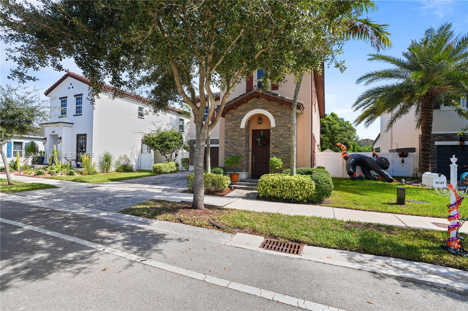 9127 Southwest 171st Court Miami, FL 33196 - Photo 53 of 54 a front view of a house with a yard and potted plants