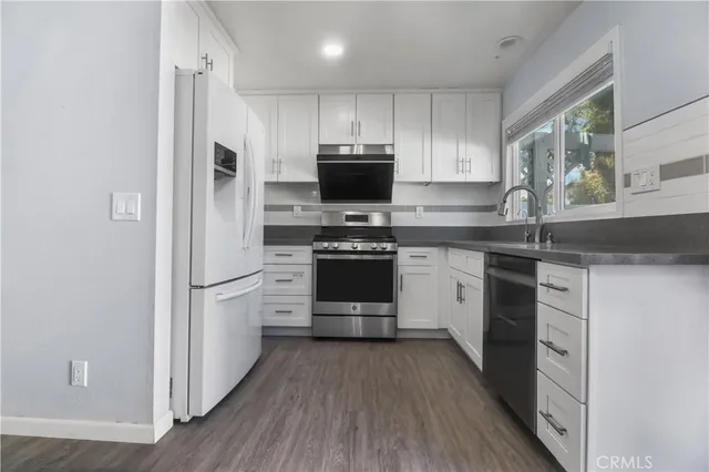a kitchen with a white stove top oven and refrigerator