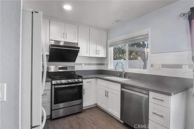a kitchen with appliances a sink and a window
