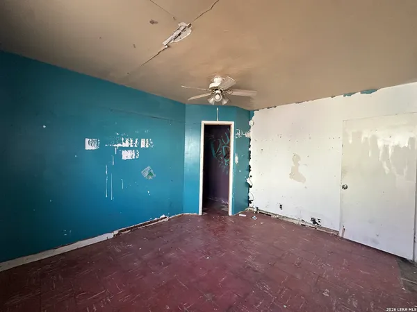 a view of a room with a chandelier fan and windows