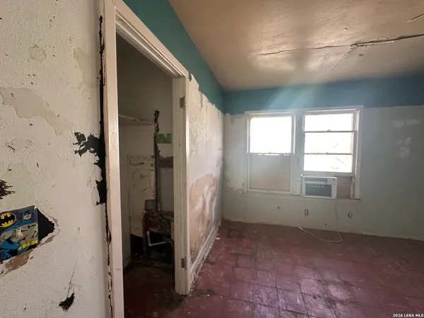 an empty room with windows and fan