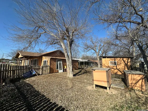 a view of a yard with a house and a tree