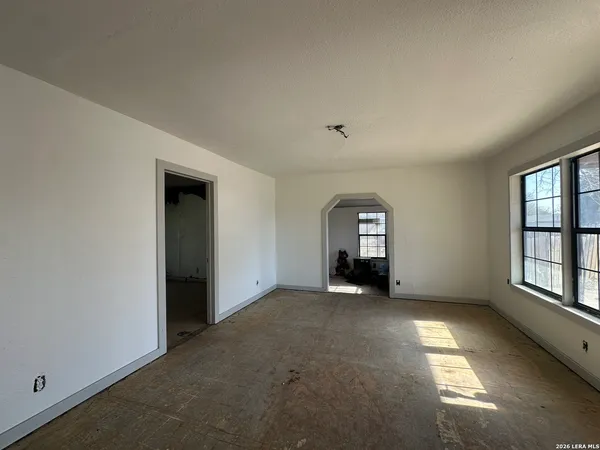 an empty room with windows and closet