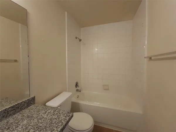 a bathroom with a granite countertop toilet a sink and bathtub