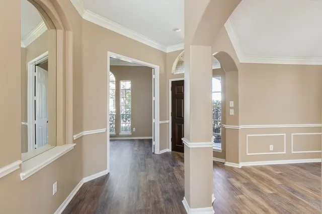 a view of a hallway with wooden floor and staircase
