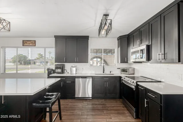 a kitchen with stainless steel appliances granite countertop a sink stove and refrigerator