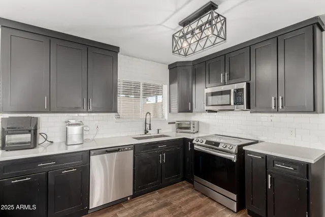 a kitchen with stainless steel appliances a sink stove and microwave