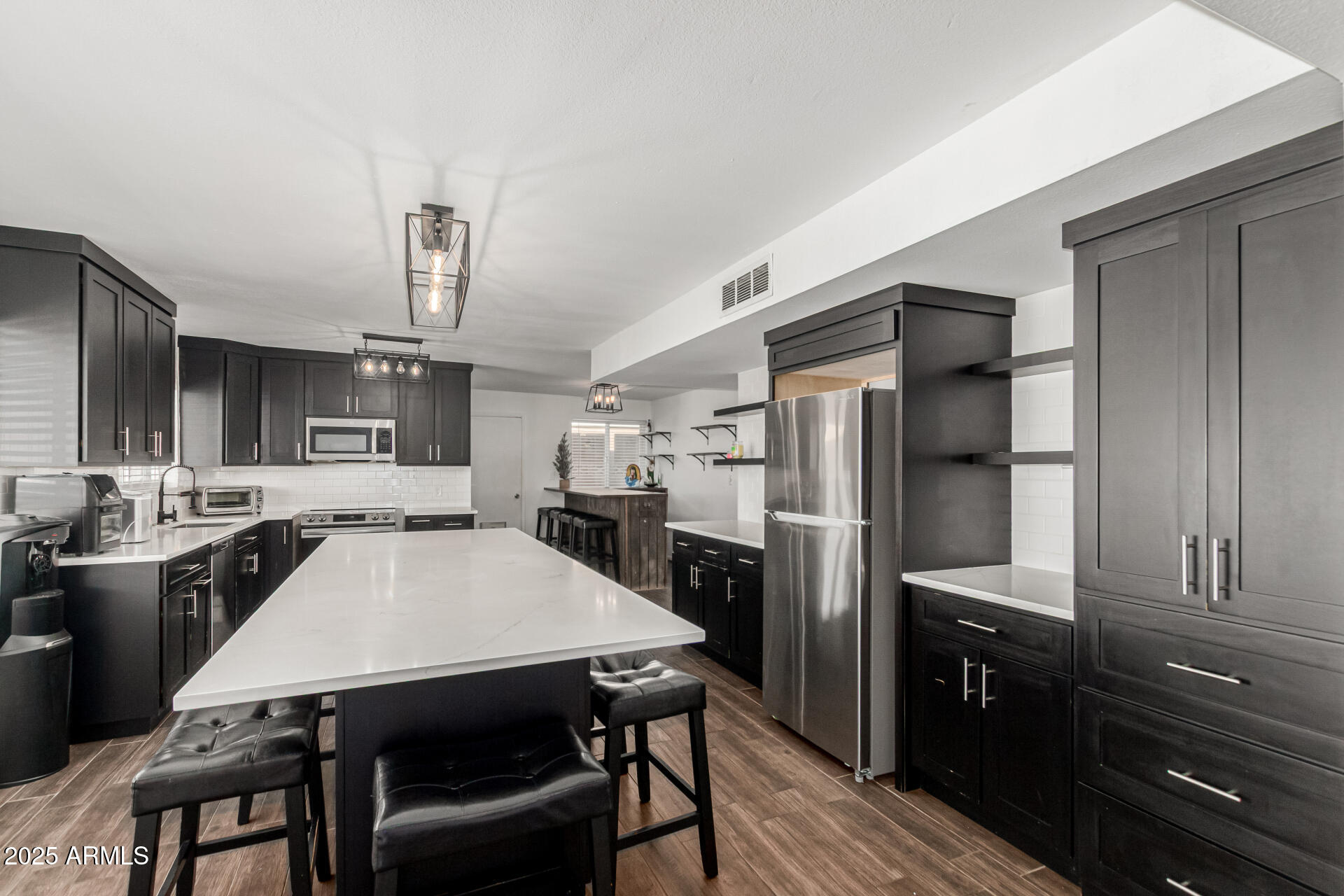 3701 West Griswold Road Phoenix, AZ 85051 - Photo 14 of 30 a kitchen with stainless steel appliances a refrigerator a stove a sink a dining table and chairs