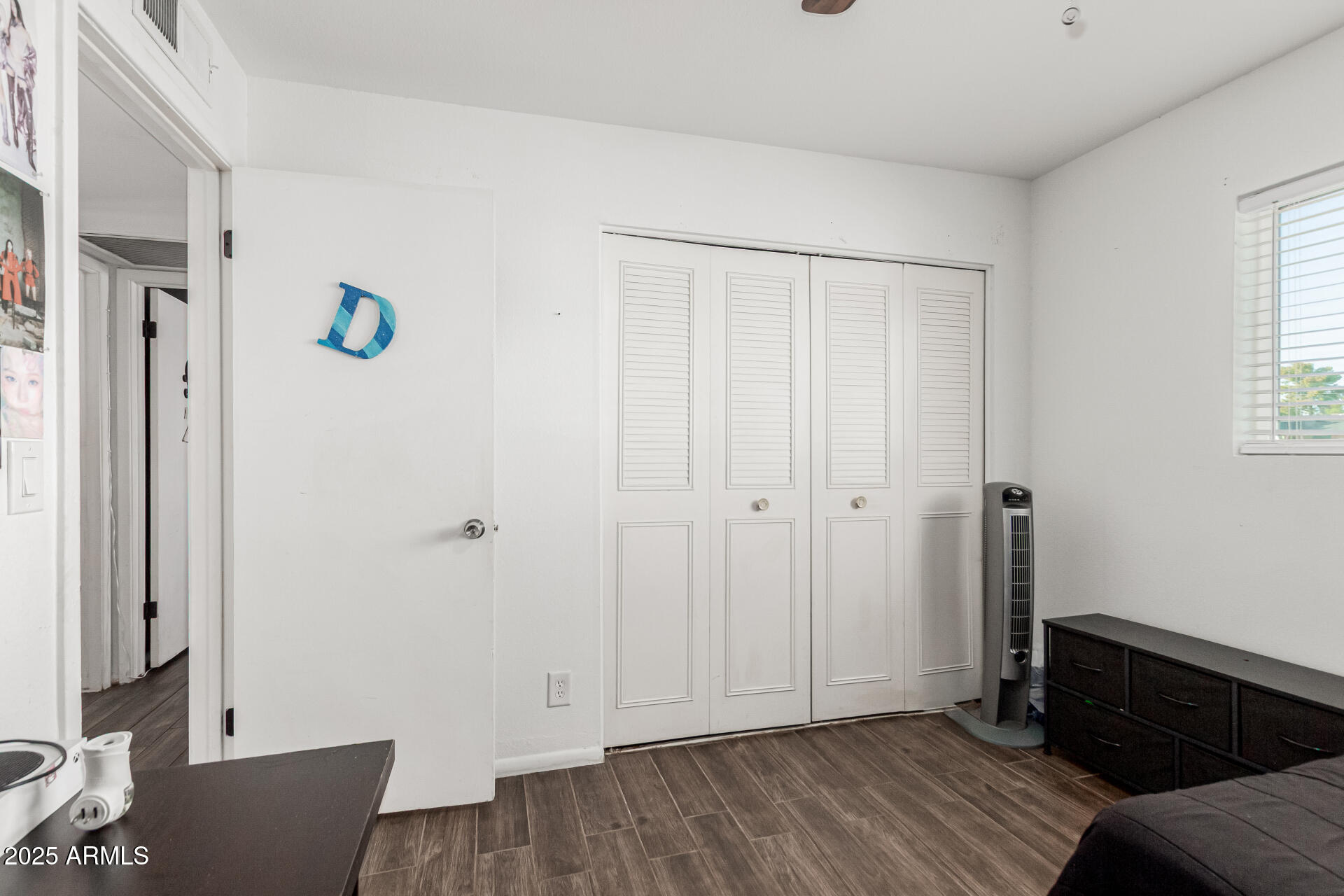 3701 West Griswold Road Phoenix, AZ 85051 - Photo 21 of 30 a view of empty room with wooden floor and fan