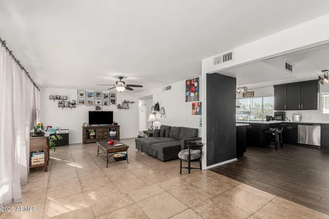 a living room with furniture a flat screen tv and kitchen view