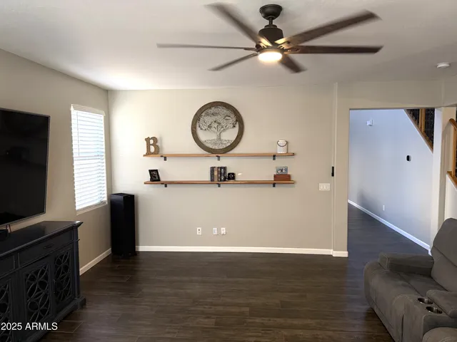 a living room with furniture and a ceiling fan