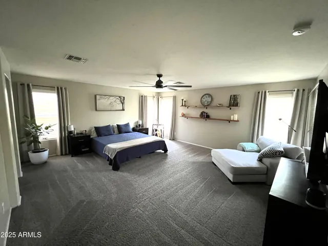 a view of a livingroom with furniture a flat screen tv ceiling fan and wooden floor