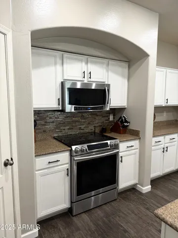 a kitchen with refrigerator cabinets and wooden floor