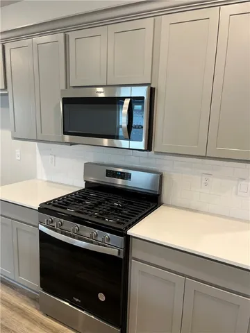 a kitchen with granite countertop white cabinets and stainless steel appliances