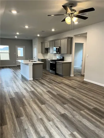 a large kitchen with stainless steel appliances kitchen island a large counter space a sink and a window