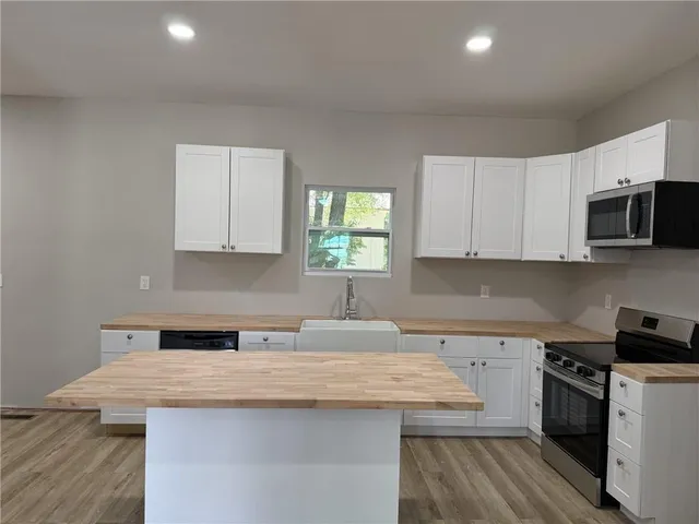a kitchen with a sink a stove and cabinets