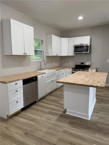 a kitchen with a sink cabinets and wooden floor