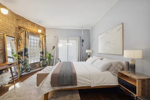 a bedroom with a bed and a lamp next to a window