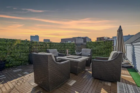 a view of a roof deck with couches and sky view
