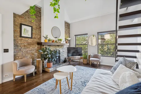 a living room with furniture chandelier and a large window
